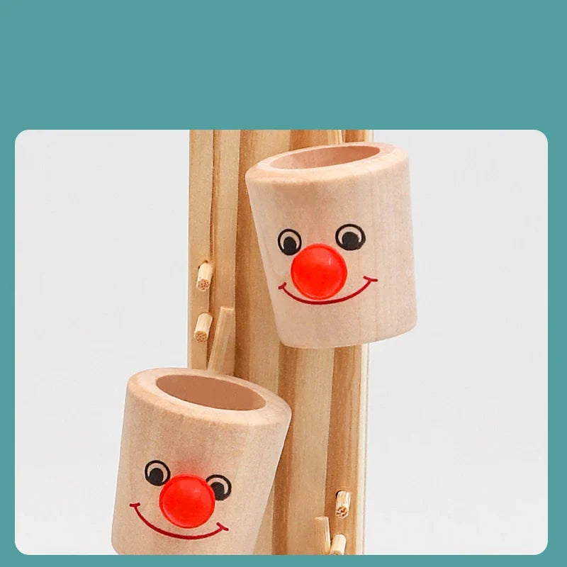 Close-up of wooden clown-face cups with red noses on the marble run
