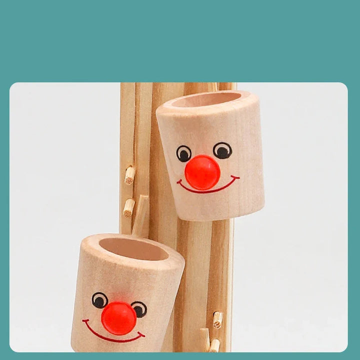 Close-up of wooden clown-face cups with red noses on the marble run