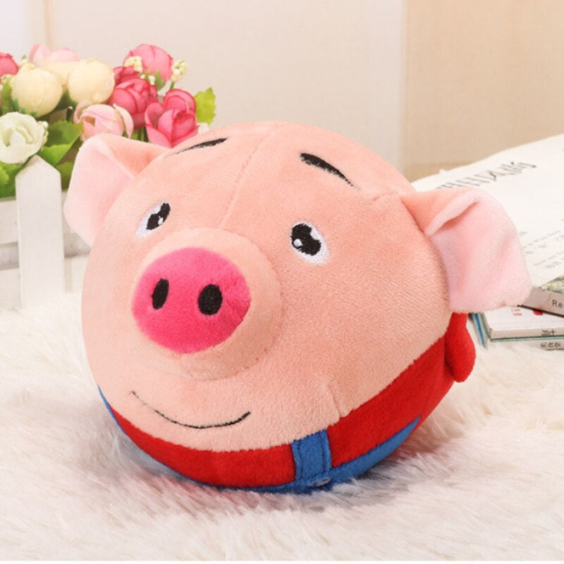 Pink pig toy ball with a red outfit, blue straps, and a smiling face