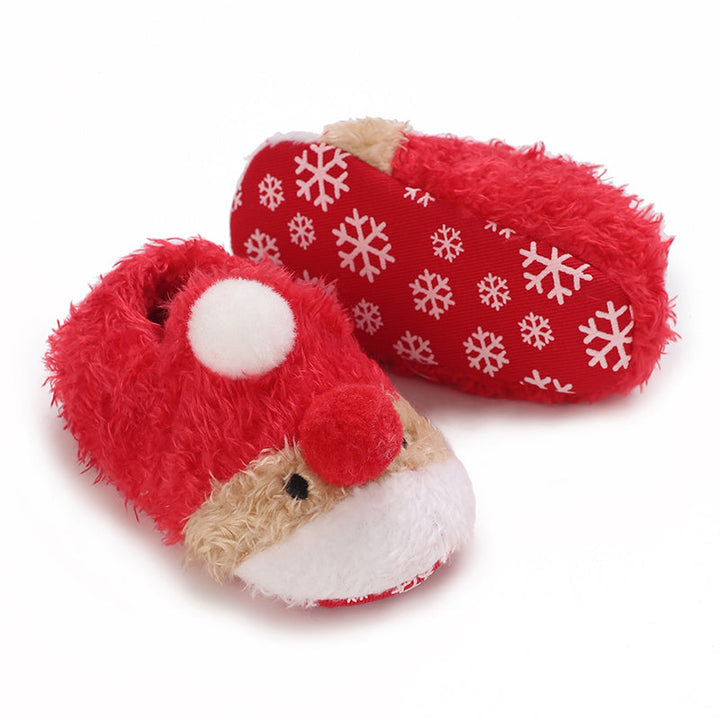 Red plush baby slippers with reindeer details and white snowflake-patterned soles