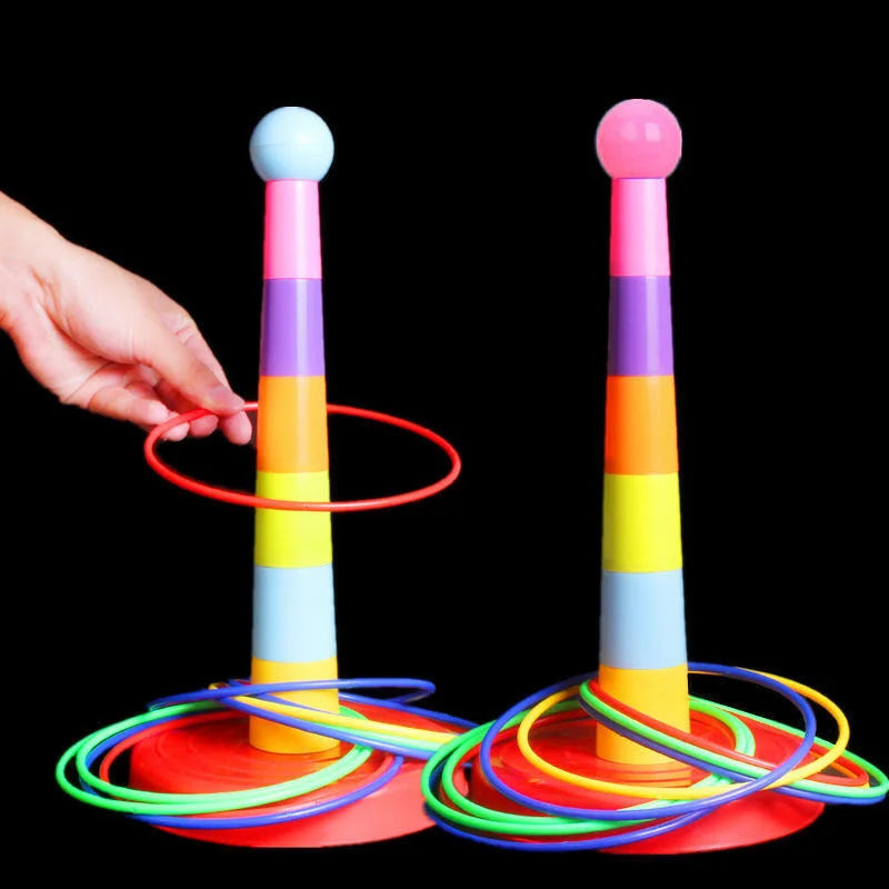 Hand holding a red ring beside two multicolored ring toss towers