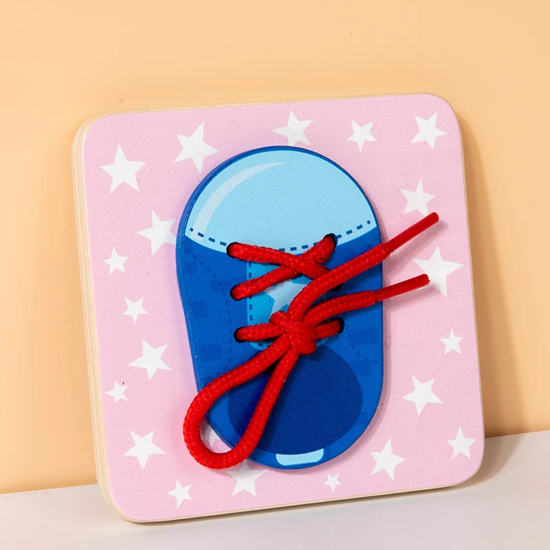 Shoelace practice busy board with a blue shoe and red laces on a pink star-patterned background.