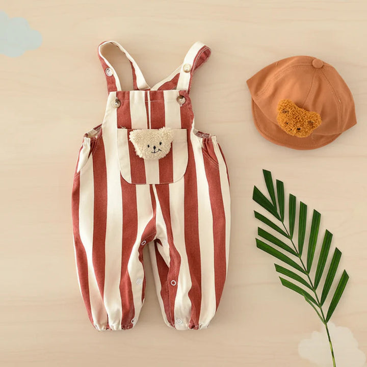Red striped teddy overall romper laid flat beside a brown hat