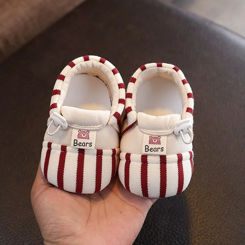 Pair of red striped baby shoes with elastic closures and bear details