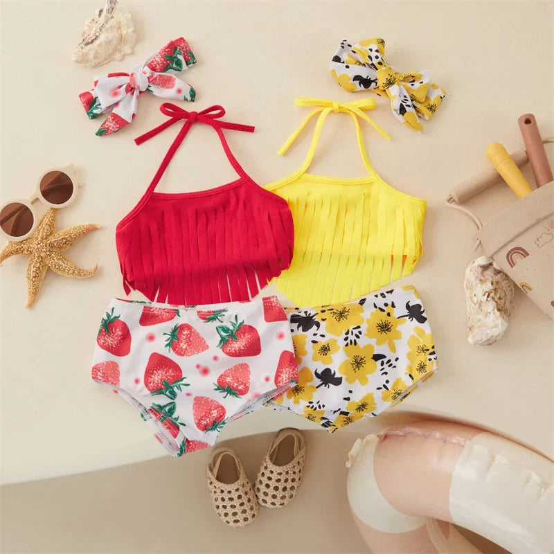 Red and yellow girls' bikini sets with fringed tops, printed bottoms and matching bow hairbands