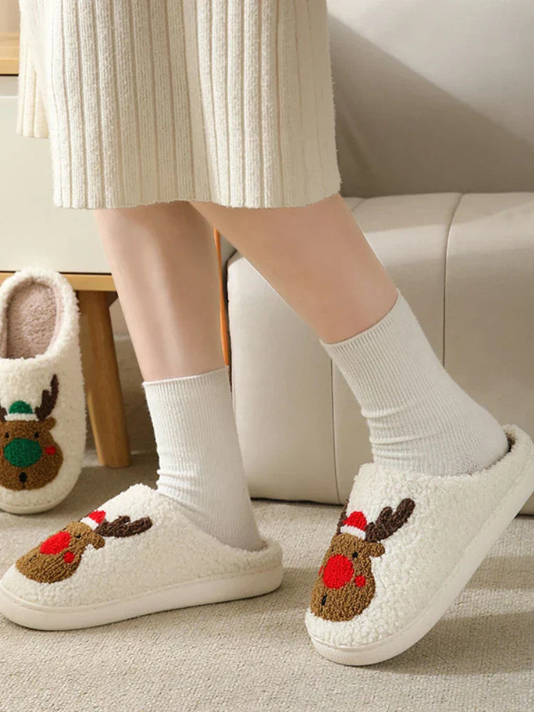 Side view of red-nosed reindeer slippers showing their open-back shape and white soles.