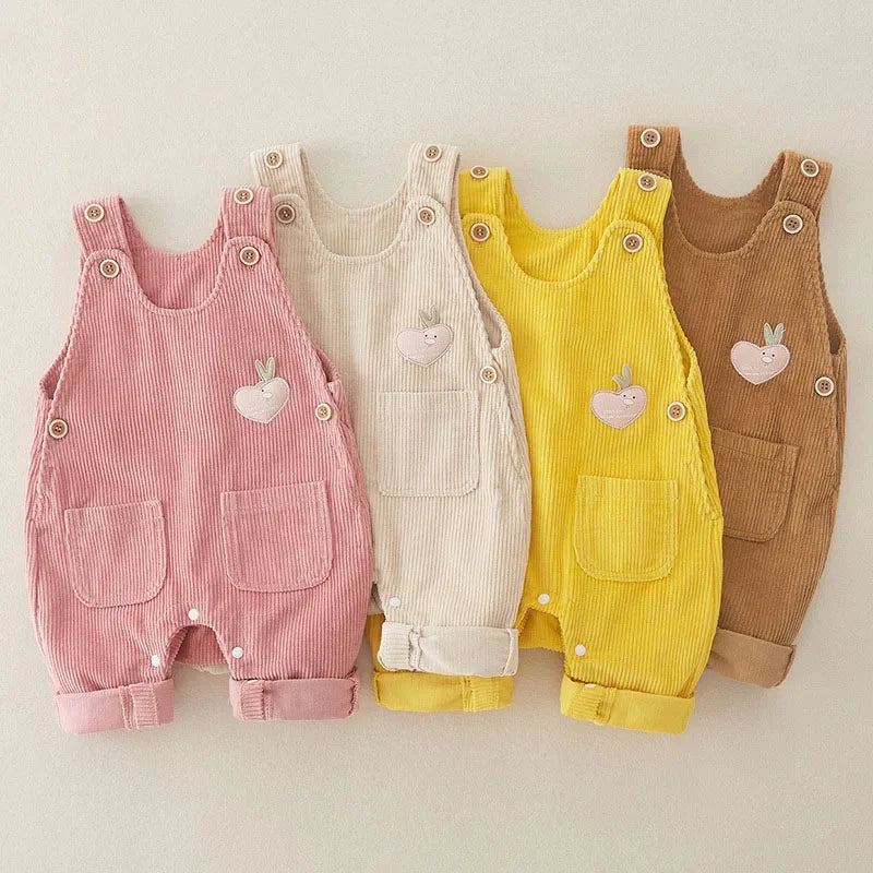 Ribbed baby overalls in pink, beige, yellow, and brown with front pockets and chest appliques