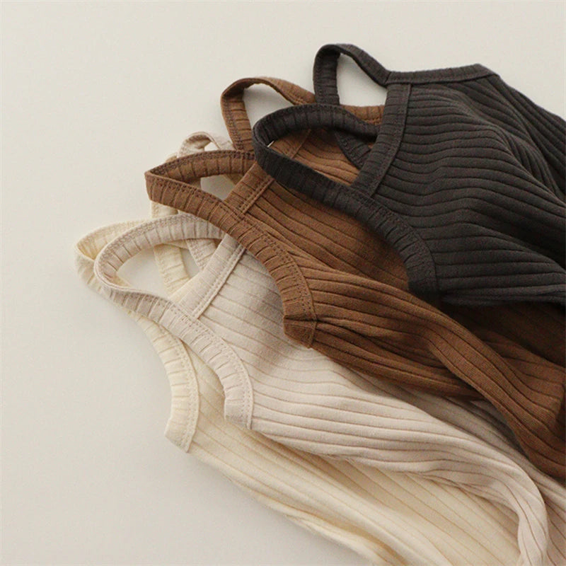 Close-up of ribbed pajama tops in light beige, brown, and black