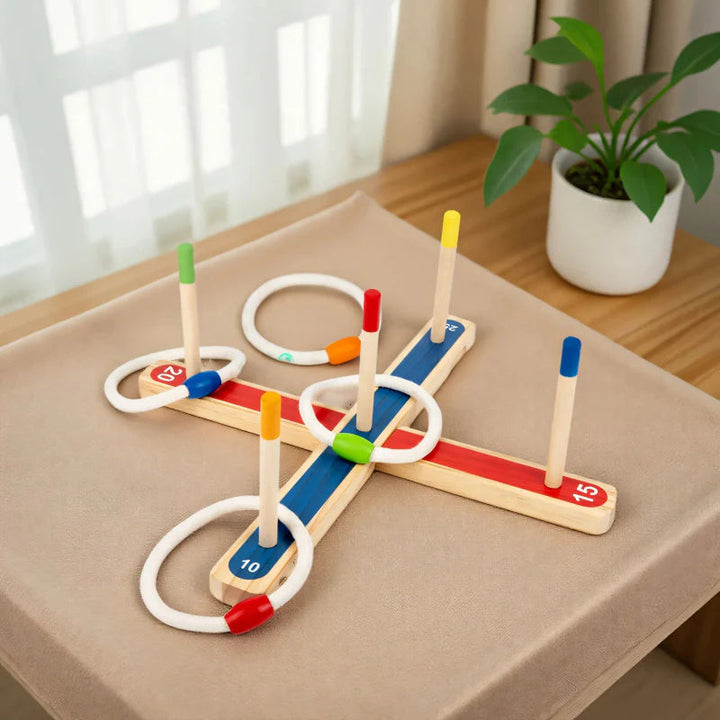 Wooden ring toss game arranged on a fabric-covered table beside a window.