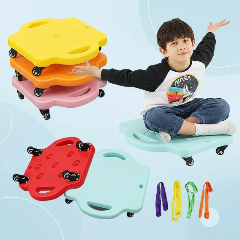 Child seated on a pale blue scooter board beside stacked boards, caster wheels, and colorful pull ropes
