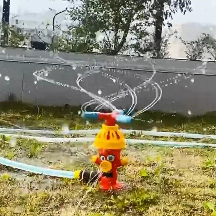 Rotating hydrant sprinkler spraying arcs of water across the grass