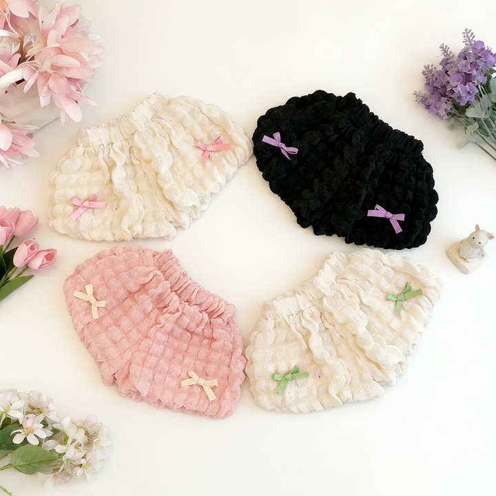 Cream, pink, and black ruffle shorts with elastic waists and small decorative bows