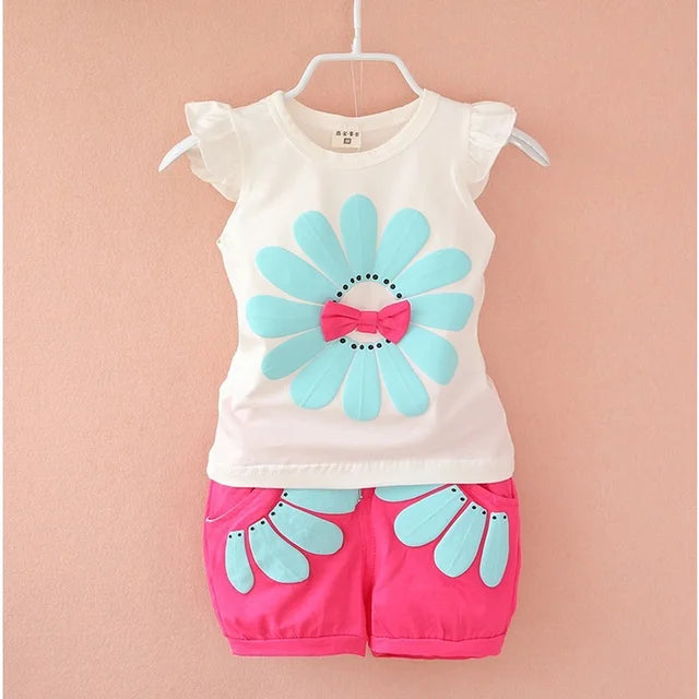 White and pink baby outfit with an aqua flower, pink bow and ruffled shoulders