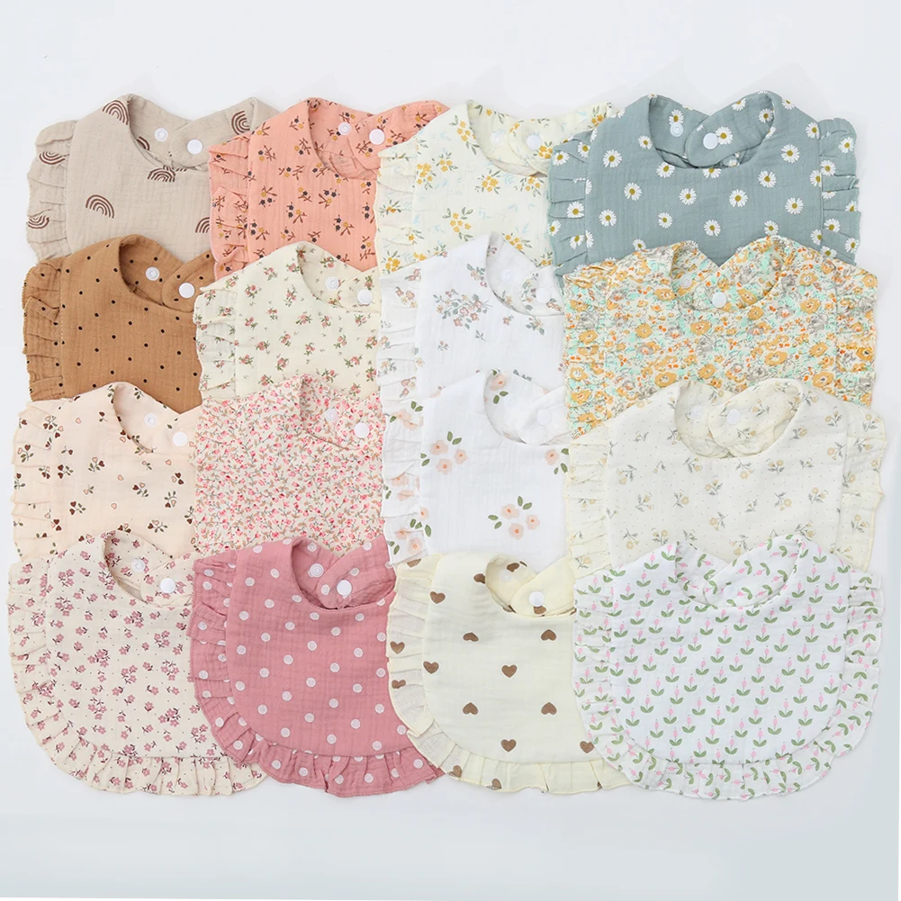 Assorted cotton baby bibs with ruffled edges in floral, dotted, heart, and rainbow prints