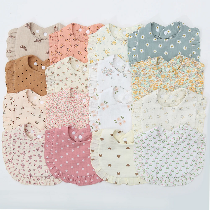 Assorted cotton baby bibs with ruffled edges in floral, dotted, heart, and rainbow prints