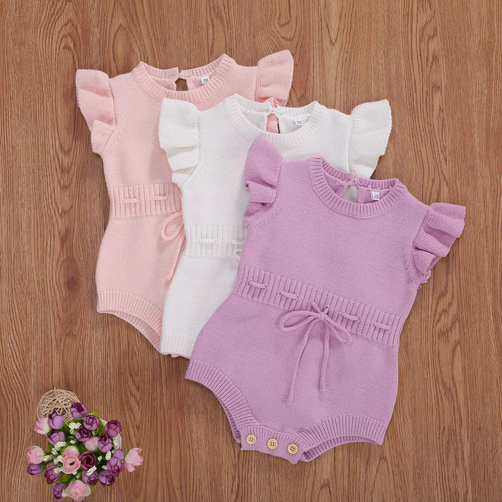 Pink, white, and light purple knit baby rompers with ruffled sleeves