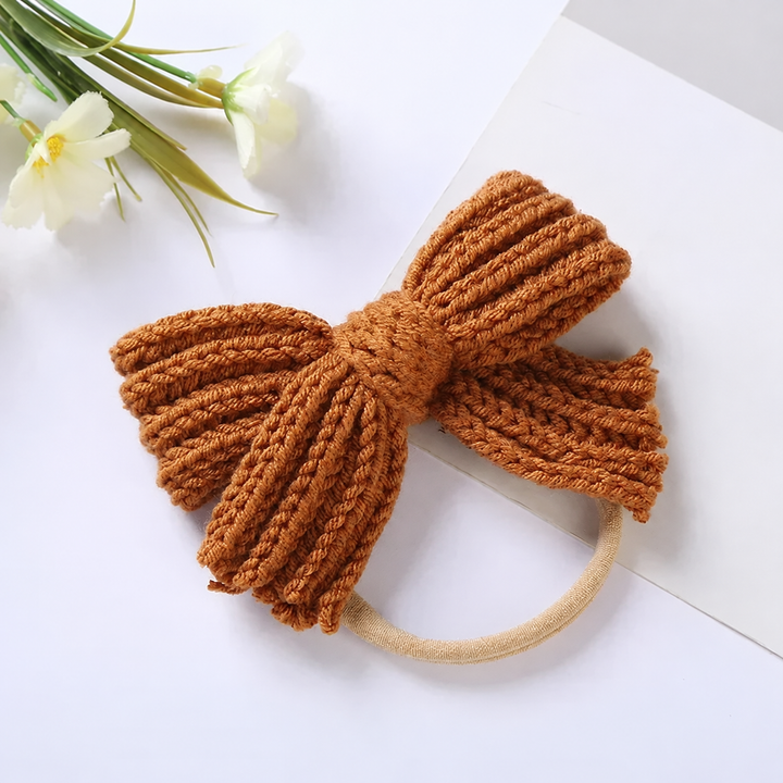 Rust-orange knitted bow headband with a beige stretch band