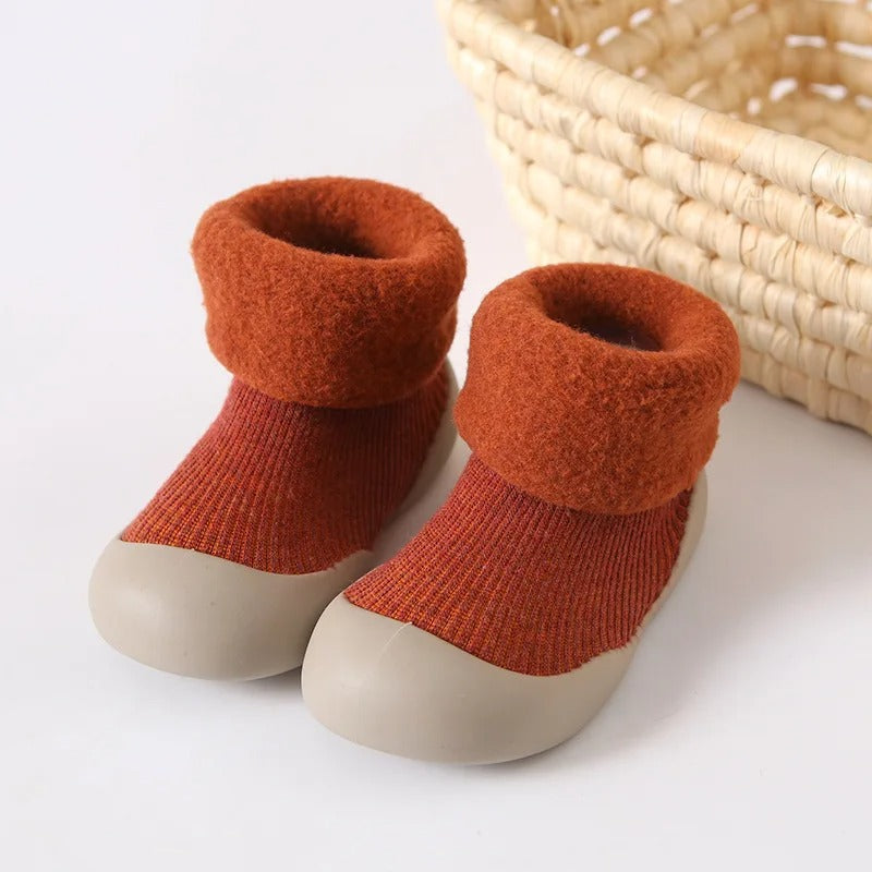 Rust-red ribbed baby socks with plush folded cuffs and light-colored soles