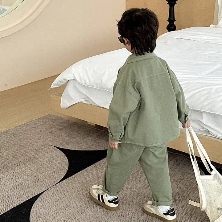 Back view of a child wearing the sage green shirt and matching cargo pants