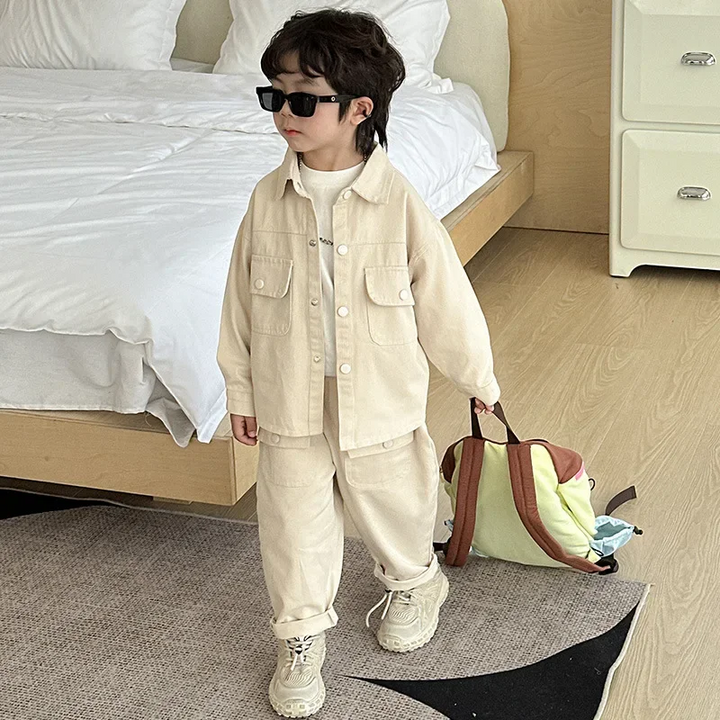 Child wearing the sand beige cargo set with sneakers and holding a bag