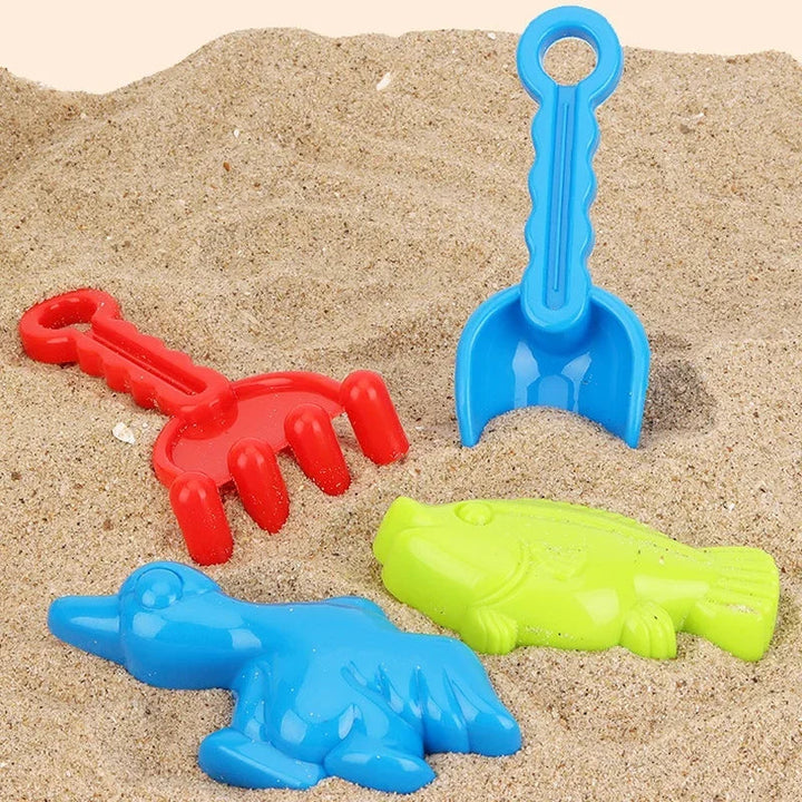 Red rake, blue shovel, and blue and green animal-shaped sand molds arranged on sand.
