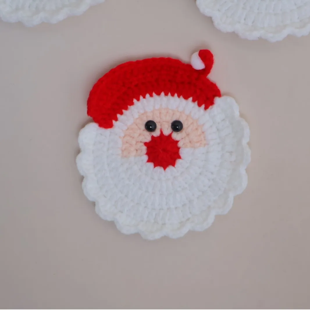 Santa Claus coaster with a red crocheted hat, white beard, and round face