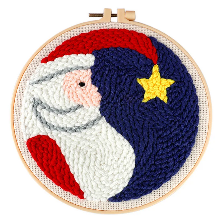 Santa punch needle hoop with a white beard, red hat, and yellow star on a dark blue background