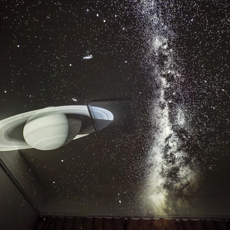 Ringed planet and Milky Way projection across a ceiling