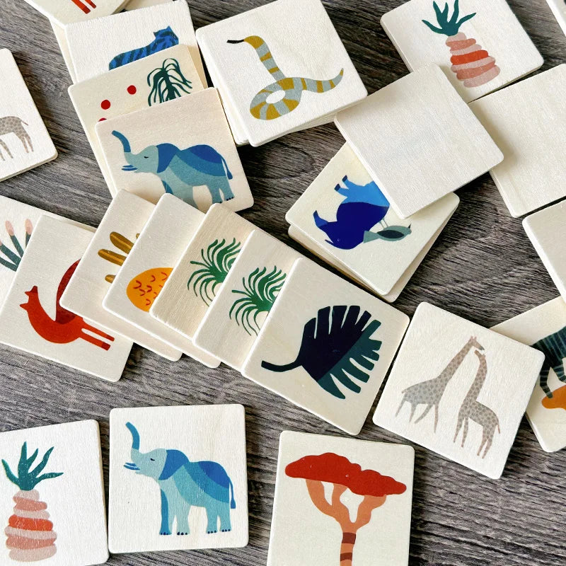 Scattered wooden memory tiles showing animal and plant illustrations alongside plain backs