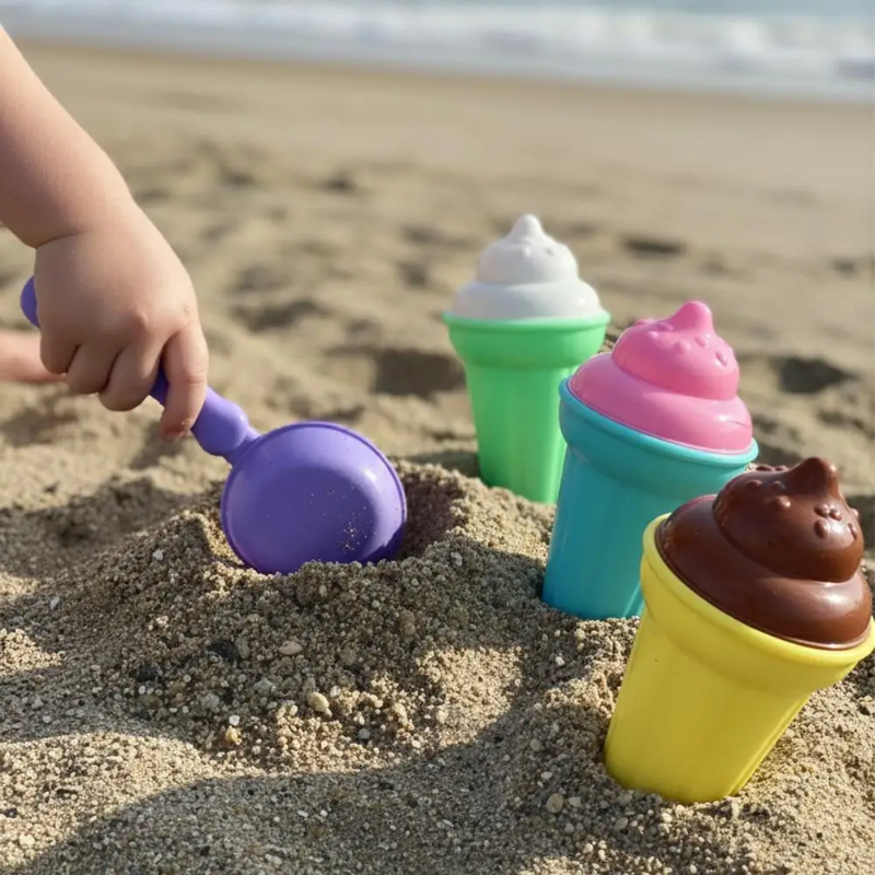 Child scooping sand beside green, blue, and yellow toy ice cream cones