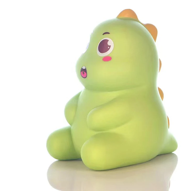 Seated green dinosaur bath toy with orange spikes along its back