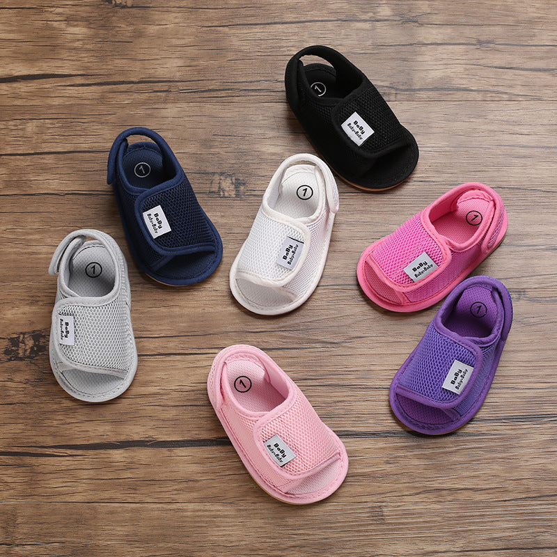 Seven baby sandal colors arranged on a wooden surface