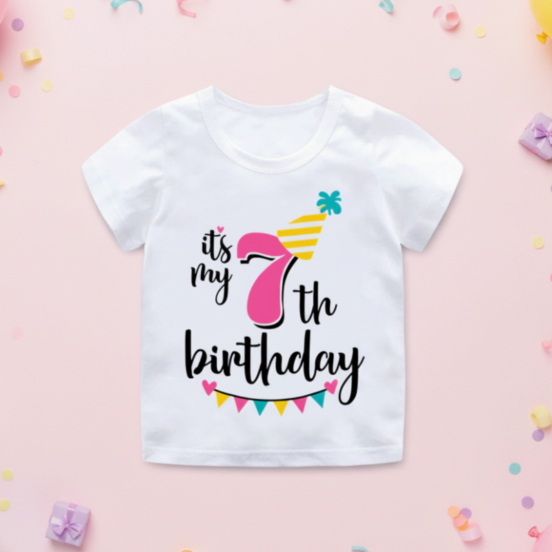 White seventh-birthday T-shirt with a pink number 7, yellow party hat, and colorful bunting