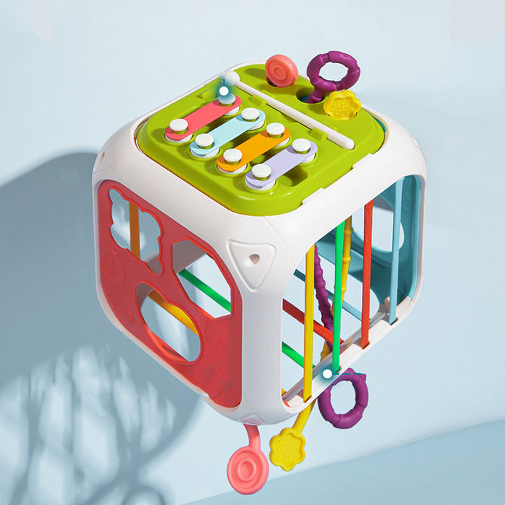 Shape sorter cube viewed from above, showing colorful keys, rings, and side openings