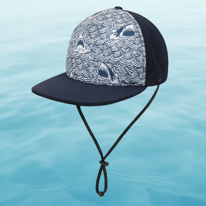Dark shark-print cap with a flat brim and adjustable black chin strap