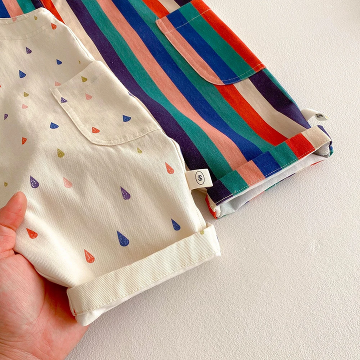 Hem and side-pocket details on cream raindrop and multicolored striped short overalls