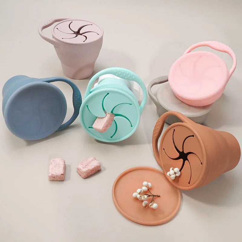Silicone snack cups with fitted covers, petal-style openings, and snacks beside them
