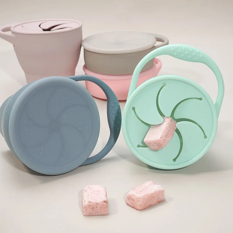 Pastel silicone snack cups with loop handles, covers, and flexible petal-style openings