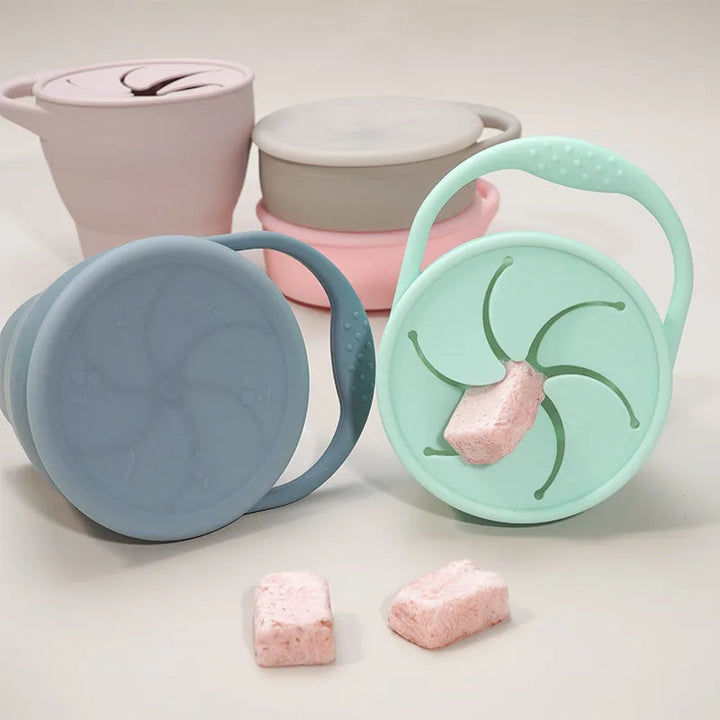 Pastel silicone snack cups with loop handles, covers, and flexible petal-style openings