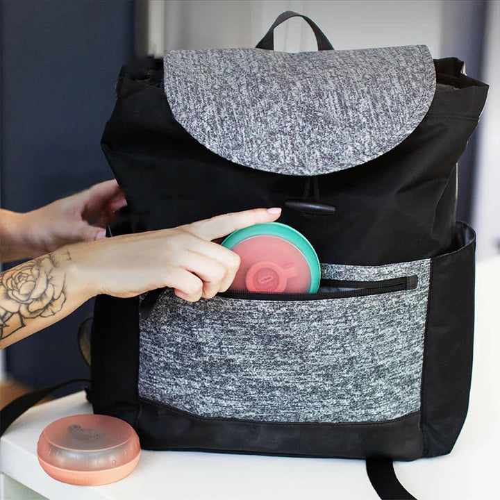 Silicone ice cream holders being tucked into a backpack pocket
