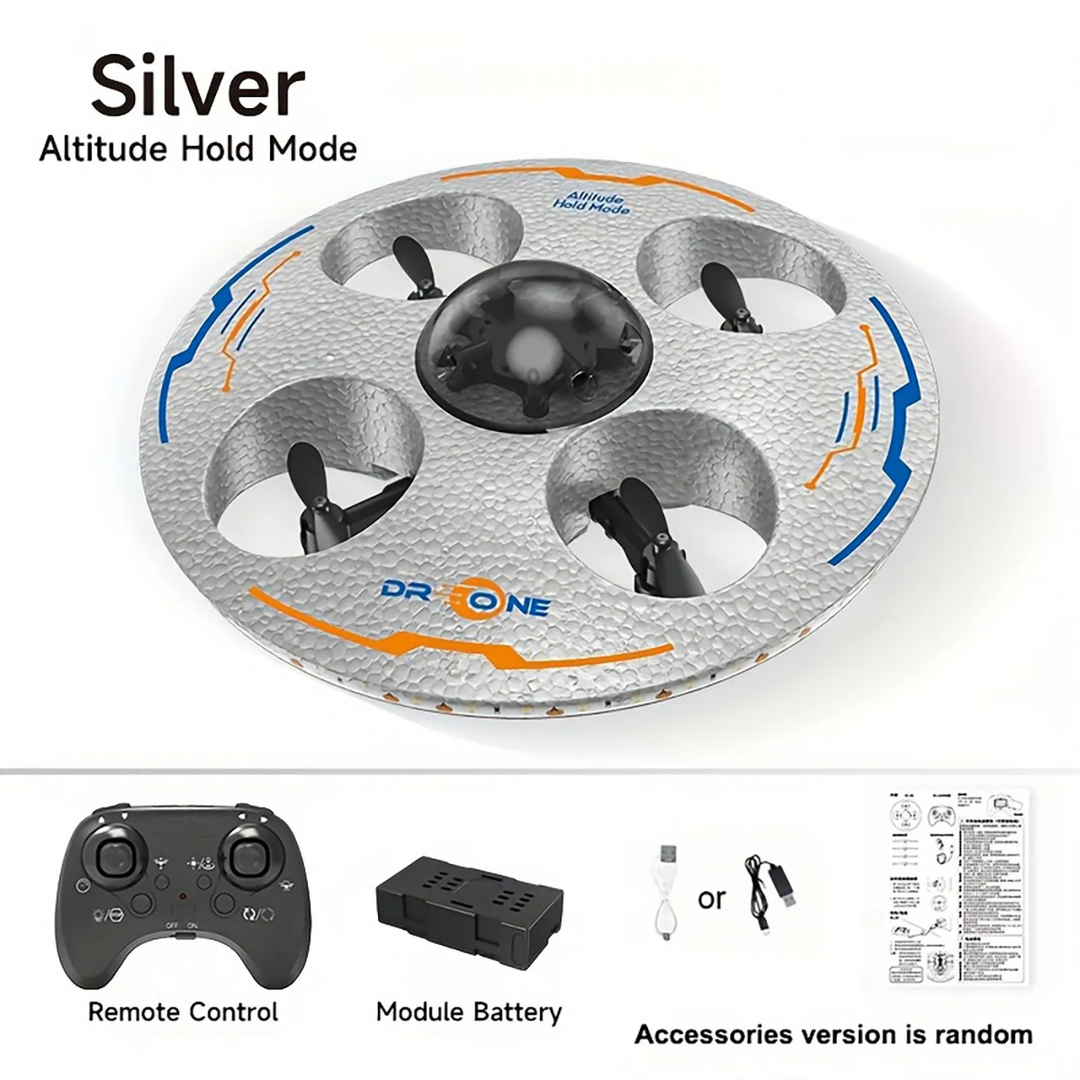Silver UFO drone shown with a remote control, modular battery, charging cable and instructions