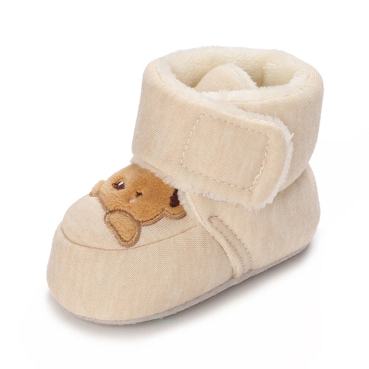 Single beige baby boot with brown bear embroidery, a plush cuff and an ankle strap