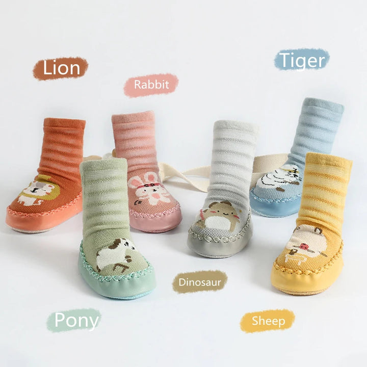 Six animal sock shoes displayed in orange, pink, gray, blue, green, and yellow
