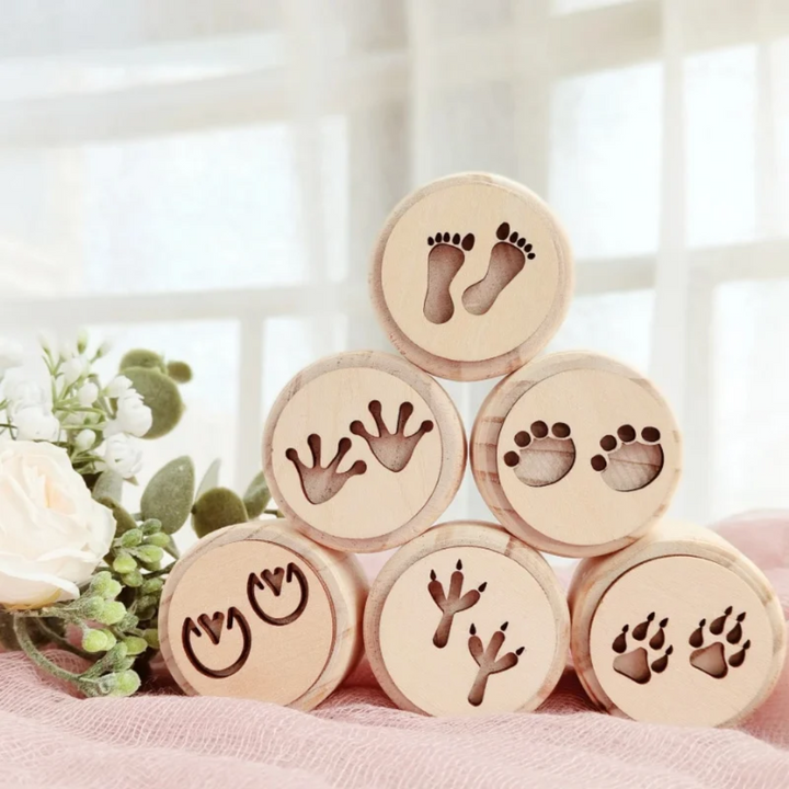 Footprint-themed wooden clay stamps stacked to show six human and animal track designs.