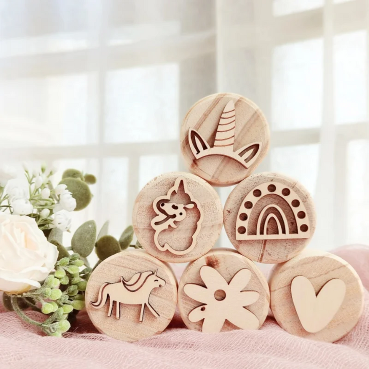 Six unicorn-themed wooden stamps displaying unicorn, horn, rainbow, flower, and heart designs.