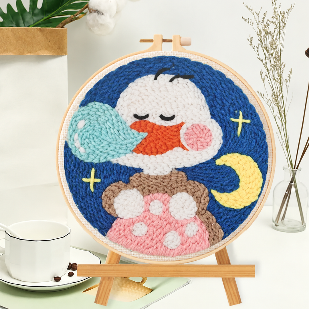 Sleeping duck punch needle hoop with a crescent moon, stars, and a pink spotted detail