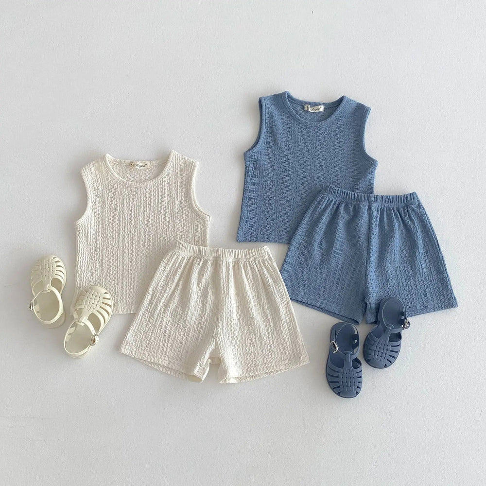 Beige and blue cotton top-and-shorts sets styled with matching sandals.