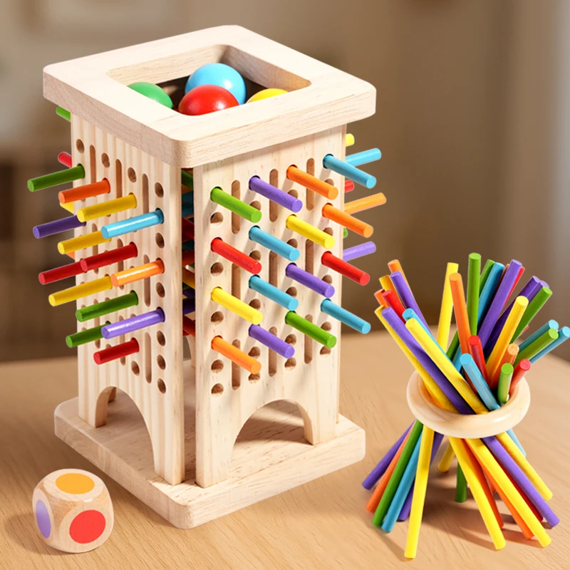 Slotted wooden stick tower holding colored balls beside a balancing-stick ring and die.