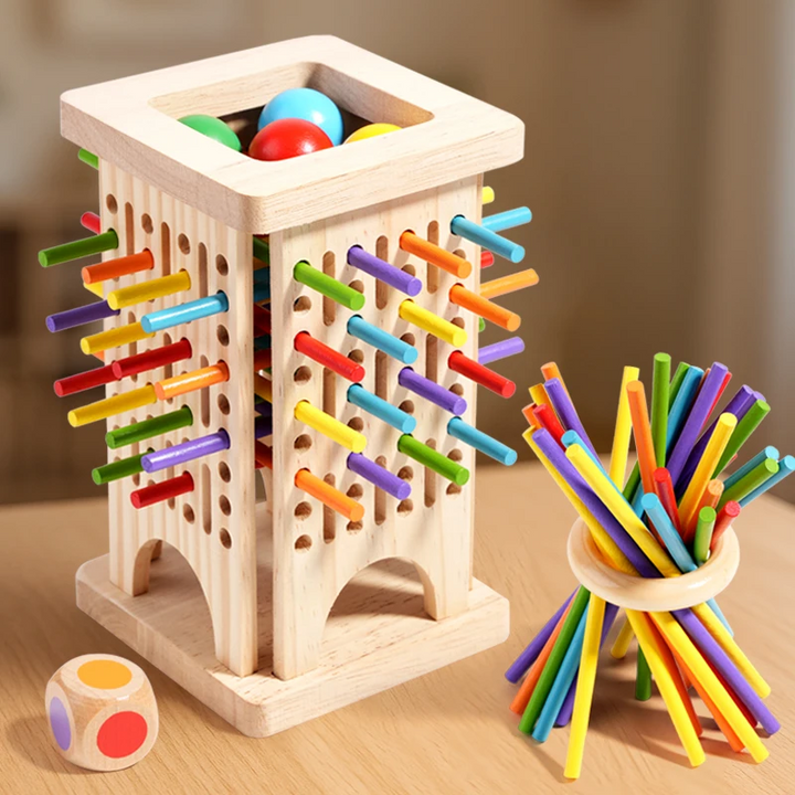 Slotted wooden stick tower holding colored balls beside a balancing-stick ring and die.