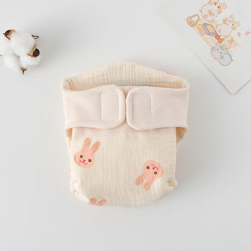 Cloth diaper with small pink rabbit faces and a cream waistband